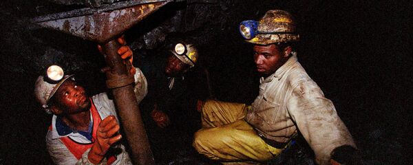 Miners work underground at the Harmony Goldmine, near Carletonville, South Africa, in this Wednesday Oct. 27, 2004 file photo. Some 3,000 miners were trapped underground when a water pipe burst and probably caused a shaft to collapse Wednesday, Oct. 3, 2007, in Harmony Gold's Elandsrand Mine near Johannesburg, South Africa's economic capital and gold-mining center - Sputnik International