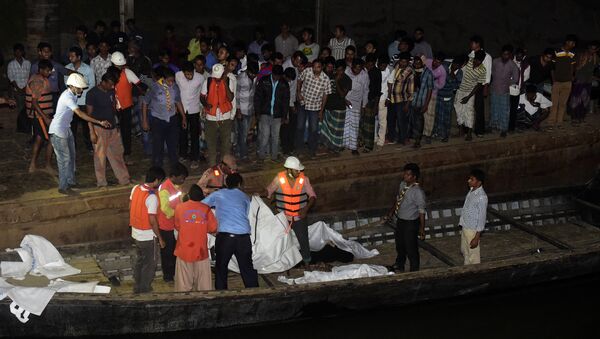 Bangladeshi rescue workers recover the body of a victim after a ferry accident at Paturia some 70kms east of Dhaka on February 22, 2015. - Sputnik International
