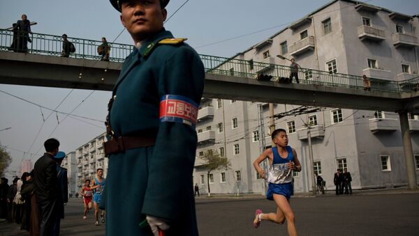 Runners pass under a pedestrian bridge in central Pyongyang during the running of the Mangyongdae Prize International Marathon in Pyongyang, North Korea on Sunday, April 13, 2014 - Sputnik International