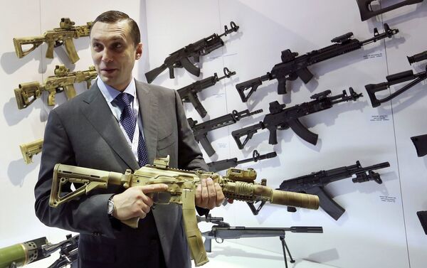 Aleksey Krivoruchko, chief executive of Russian firearms maker Kalashnikov Concern, holds a weapon during the International Defence Exhibition (IDEX) in Abu Dhabi February 22, 2015 - Sputnik International
