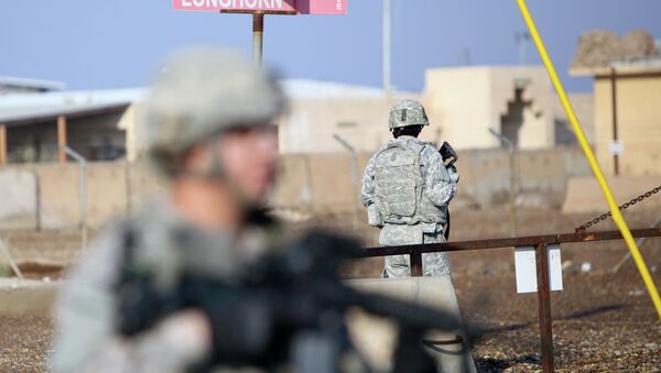 US soldiers stand guard at the Taji base complex which hosts Iraqi and US troops and is located thirty kilometres north of the capital Baghdad - Sputnik International