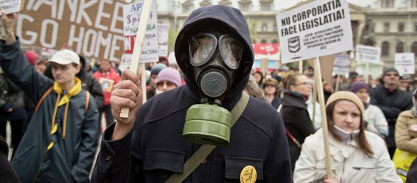 An anti-fracking demonstrator wears a gas mask and holds flowers during a protest in Bucharest, Romania, Sunday, April 6, 2014 An anti-fracking demonstrator wears a gas mask and holds flowers during a protest in Bucharest, Romania, Sunday, April 6, 2014 - Sputnik International