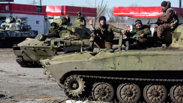 Fighters with the  self-proclaimed Donetsk People's Republic army sit on top of mobile artillery units in the town of Debaltseve February 22, 2015 - Sputnik International