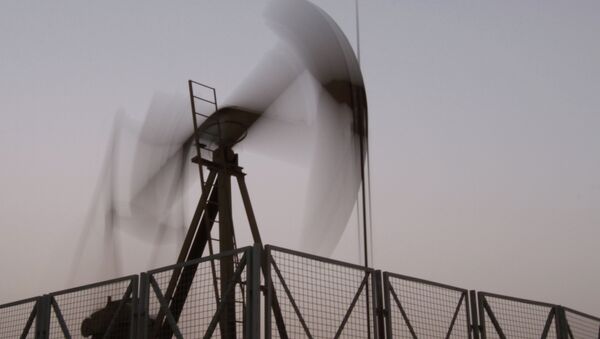 An oil pump jack works at sunset in the desert oil fields of Sakhir, Bahrain. - Sputnik International