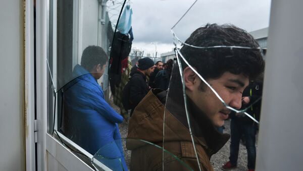 Migrants stand behind a broken window at the Foreigners Detention Center in Amygdaleza, Greece, north of the capital Athens, following the apparent suicide of a Pakistani detainee on Saturday, Feb. 14, 2015 - Sputnik International