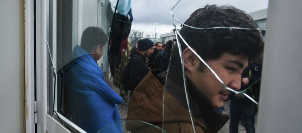 Migrants stand behind a broken window at the Foreigners Detention Center in Amygdaleza, Greece, north of the capital Athens, following the apparent suicide of a Pakistani detainee on Saturday, Feb. 14, 2015 Migrants stand behind a broken window at the Foreigners Detention Center in Amygdaleza, Greece, north of the capital Athens, following the apparent suicide of a Pakistani detainee on Saturday, Feb. 14, 2015 - Sputnik International