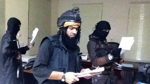 Shakir Waheib, a leader in the al-Qaida-linked Islamic State of Iraq and the Levant (ISIL), center, searching a government office in Ramadi, in Iraq's Anbar Province - Sputnik International