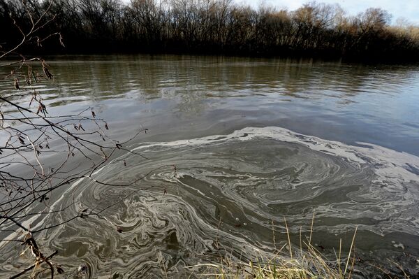Signs of coal ash swirl in the water in the Dan River in Danville, Va. A year after the sudden collapse of an old drainage pipe triggered the third largest coal ash spill in U.S. history. Signs of coal ash swirl in the water in the Dan River in Danville, Va. A year after the sudden collapse of an old drainage pipe triggered the third largest coal ash spill in U.S. history. - Sputnik International