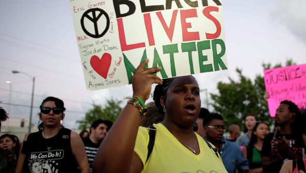 Desiree Griffiths, 31, of Miami, holds up a sign saying Black Lives Matter, with the names of Michael Brown and Eric Garner, two black men recently killed by police, during a protest - Sputnik International