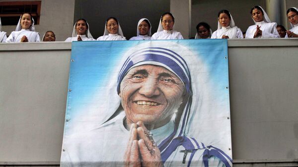 Nuns of Missionaries of Charity sing a hymn as a portrait of Mother Teresa hangs from a balcony during a congregation to mark her death anniversary in Kolkata, India, Monday, Sept. 5, 2011 - Sputnik International