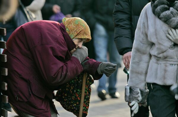 A pensioner begs for money as pedestrians pass by in central Kiev, Ukraine A pensioner begs for money as pedestrians pass by in central Kiev, Ukraine - Sputnik International