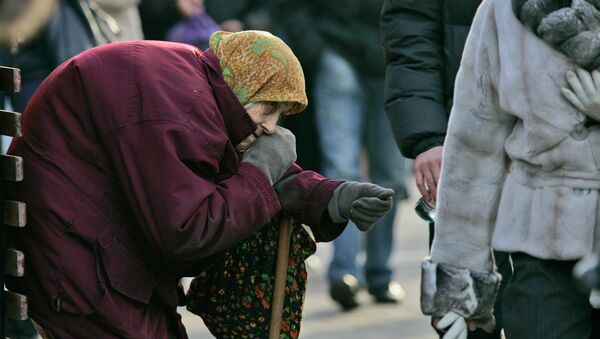 A pensioner begs for money as pedestrians pass by in central Kiev, Ukraine - Sputnik International