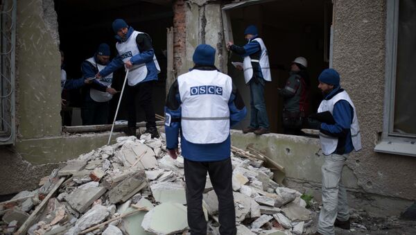 Organization for Security and Co-operation in Europe (OSCE) monitors investigate outside a kindergarten damaged in Saturday's shelling in which scores of people were killed and injured in Mariupol - Sputnik International