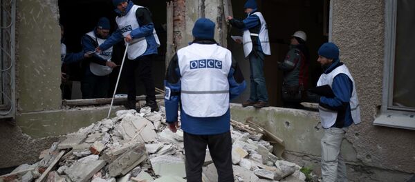 Organization for Security and Co-operation in Europe (OSCE) monitors investigate outside a kindergarten damaged in Saturday's shelling in which scores of people were killed and injured in Mariupol - Sputnik International