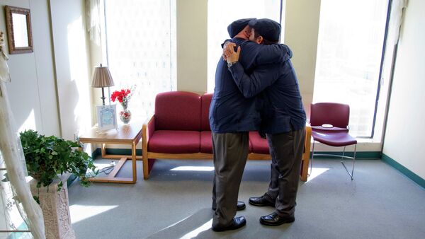 Charles Windham, left, 53, and Edgard Perez, 40, embrace after they were married at the marriage license bureau - Sputnik International