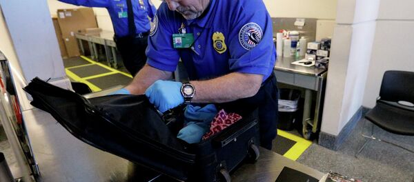 A TSA agent checks a bag at a security checkpoint area at Midway International Airport in Chicago. A TSA agent checks a bag at a security checkpoint area at Midway International Airport in Chicago. - Sputnik International