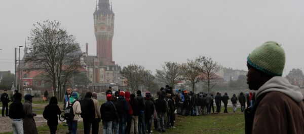Migrants queue during a daily food distribution close to the city hall in Calais, northern France Migrants queue during a daily food distribution close to the city hall in Calais, northern France - Sputnik International