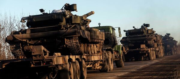 Military trucks from the Ukrainian armed forces transport tanks on the road near Artemivsk, eastern Ukraine, February 24, 2015 - Sputnik International