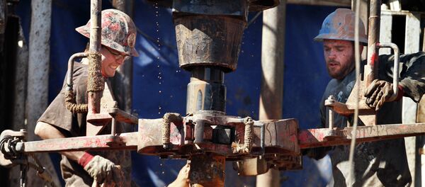 Oil field workers drill into the Gypsum Hills near Medicine Lodge, Kan. Plunging crude prices are hitting oil producers especially hard in places like Kansas - Sputnik International