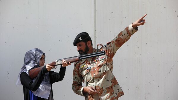 Pakistan Rangers soldier gestures as he instructs a female student of Nadirshaw Eduljee Dinshaw (NED) University during a counter-terrorism training demonstration at the Rangers Shooting & Saddle Club (RSSC) on the outskirts of Karachi, February 24, 2015 - Sputnik International