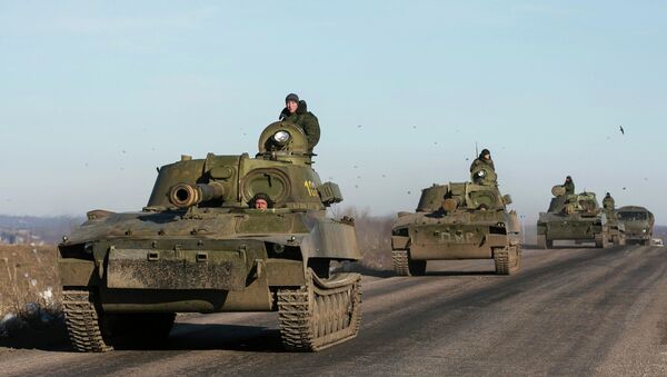 Soldiers of the self-proclaimed Donetsk People's Republic army ride in mobile artillery cannons as they are pulling back from from Debaltseve - Sputnik International