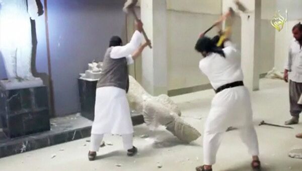 Men use sledgehammers on a toppled statue in a museum at a location said to be Mosul in this still image taken from an undated video. - Sputnik International