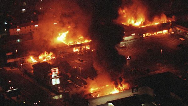 Several buildings in a Los Angeles shopping center fully engulfed in flames during the 1992 riots. - Sputnik International