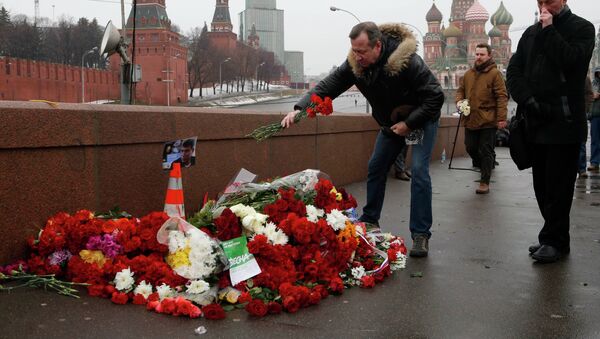 People come to lay flowers at the site, where Boris Nemtsov was shot dead, with St. Basil's Cathedral (R) and the Kremlin walls seen in the background, in central Moscow, February 28, 2015. - Sputnik International