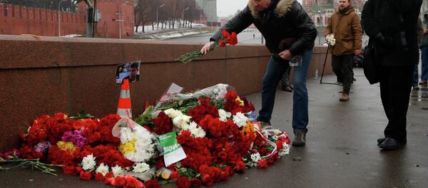 People come to lay flowers at the site, where Boris Nemtsov was shot dead, with St. Basil's Cathedral (R) and the Kremlin walls seen in the background, in central Moscow, February 28, 2015. People come to lay flowers at the site, where Boris Nemtsov was shot dead, with St. Basil's Cathedral (R) and the Kremlin walls seen in the background, in central Moscow, February 28, 2015. - Sputnik International