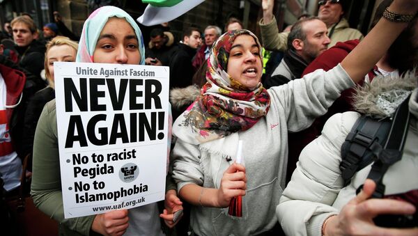 A girl holds a placard as she takes part in a counter-demonstrations against a rally by supporters of the Pegida movement in Newcastle, northern England - Sputnik International