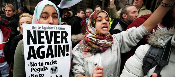 A girl holds a placard as she takes part in a counter-demonstrations against a rally by supporters of the Pegida movement in Newcastle, northern England A girl holds a placard as she takes part in a counter-demonstrations against a rally by supporters of the Pegida movement in Newcastle, northern England - Sputnik International