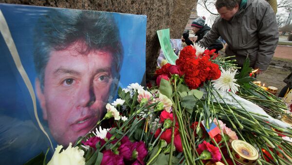 People lay flowers in memory of Boris Nemtsov, seen at left, at the monument of political prisoners 'Solovetsky Stone' in central St. Petersburg, Russia, Saturday, Feb. 28, 2015. - Sputnik International