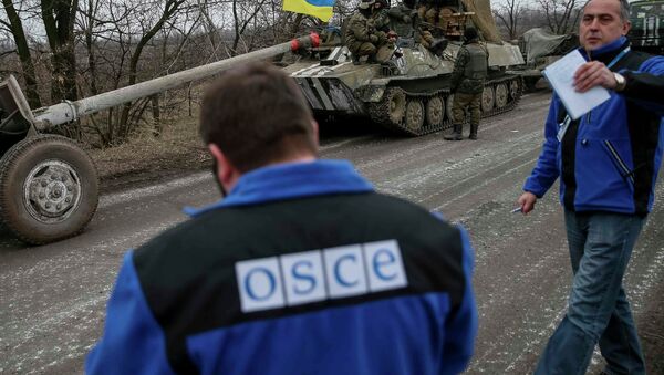 Members of Special Monitoring Mission of the Organization for Security and Cooperation (OSCE) to Ukraine walk along a convoy of Ukrainian armed forces in Paraskoviyvka, eastern Ukraine - Sputnik International