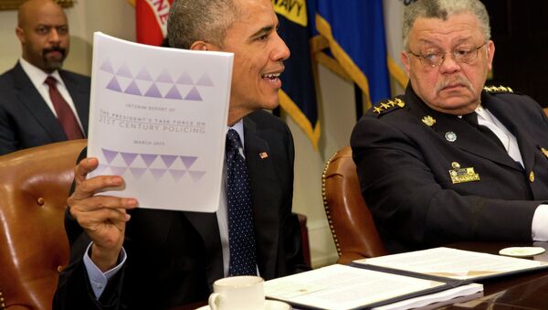 Philadelphia Police Commissioner Charles Ramsey watches at right as President Barack Obama holds up a copy of the interim report of the President's Task Force on 21st Century Policing. - Sputnik International