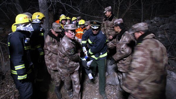 Rescue workers remove an injured person from the site after a bus accident in Henan province, March 3, 2015 - Sputnik International