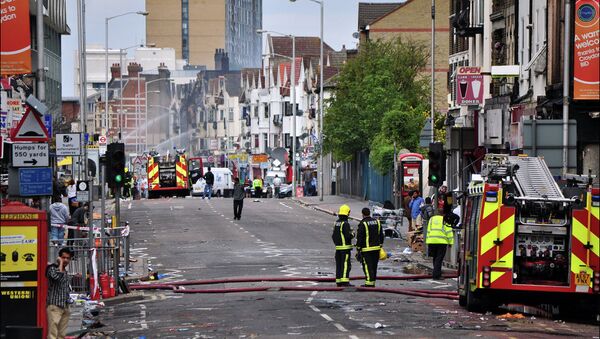 Croydon road looking like a tornado swept up it as fire tenders spray water twelve hours after the fires were set during riots in 2011.  - Sputnik International