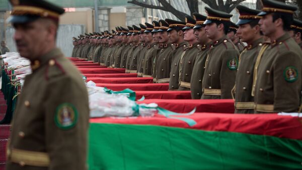 Afghan guards of honor stand next to the 21 coffins of Afghan national army soldiers during a ceremony at a military hospital in Kabul on February 24, 2014 - Sputnik International