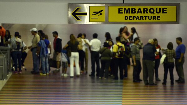 People queue with their luggage at the departure area of the Maiquetia international airport that serves Caracas on July 3, 2014 - Sputnik International