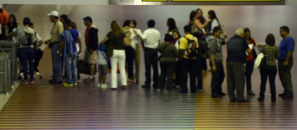 People queue with their luggage at the departure area of the Maiquetia international airport that serves Caracas on July 3, 2014 People queue with their luggage at the departure area of the Maiquetia international airport that serves Caracas on July 3, 2014 - Sputnik International