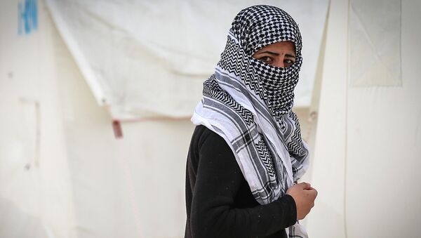 A Syrian refugee who fled violence in and around the Syrian city of Ayn al-Arab or Kobani walks in a camp recently opened by Turkey, in the border town of Suruc, Turkey, Friday, Jan. 30, 2015 - Sputnik International