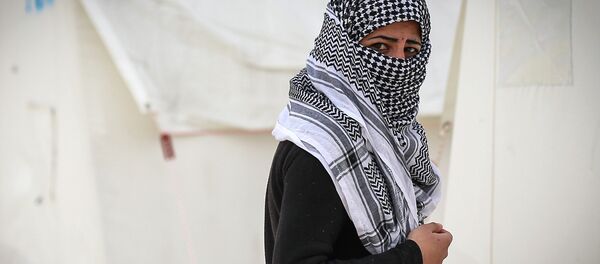 A Syrian refugee who fled violence in and around the Syrian city of Ayn al-Arab or Kobani walks in a camp recently opened by Turkey, in the border town of Suruc. A Syrian refugee who fled violence in and around the Syrian city of Ayn al-Arab or Kobani walks in a camp recently opened by Turkey, in the border town of Suruc. - Sputnik International