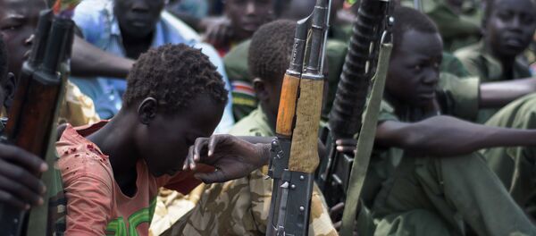 A file photo taken on February 10, 2015 shows young boys, child soldiers sitting on with their rifles A file photo taken on February 10, 2015 shows young boys, child soldiers sitting on with their rifles - Sputnik International