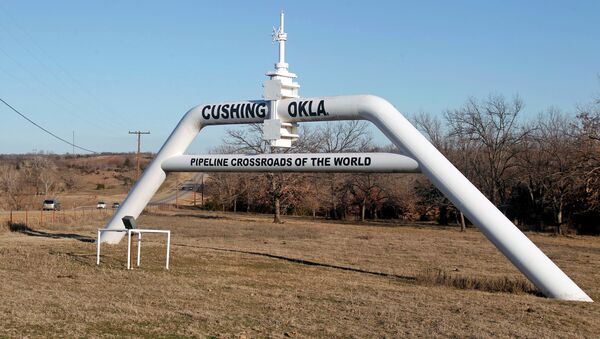 This Wednesday, Feb. 1, 2012 photo shows a marker declaring Cushing, Okla. as the pipeline crossroads of the world, in Cushing. For the past seven weeks, the United States has been producing and importing an average of 1 million more barrels of oil every day than it is consuming. - Sputnik International