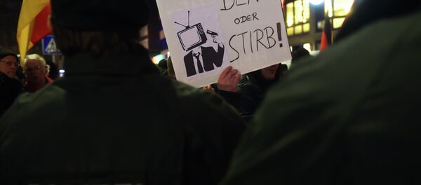 A sympathizer of Duegida, a local copycat of Dresden's right-wing populist movement PEGIDA (Patriotic Europeans Against the Islamisation of the Occident) holds up a placard reading 'Think or die!' in Duesseldorf, western Germany on February 2, 2015 A sympathizer of Duegida, a local copycat of Dresden's right-wing populist movement PEGIDA (Patriotic Europeans Against the Islamisation of the Occident) holds up a placard reading 'Think or die!' in Duesseldorf, western Germany on February 2, 2015 - Sputnik International