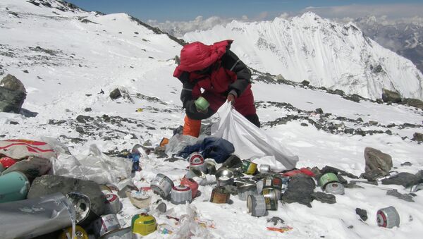 This picture taken on May 23, 2010 shows a Nepalese sherpa collecting garbage, left by climbers, at an altitude of 8,000 metres during the Everest clean-up expedition at Mount Everest - Sputnik International