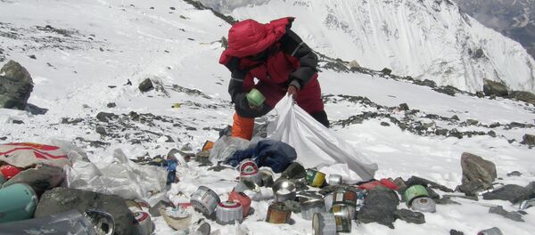 This picture taken on May 23, 2010 shows a Nepalese sherpa collecting garbage, left by climbers, at an altitude of 8,000 metres during the Everest clean-up expedition at Mount Everest - Sputnik International