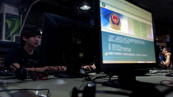 In this Aug. 19, 2013 file photo, computer users sit near a monitor display with a message from the Chinese police on the proper use of the Internet at an Internet cafe in Beijing, China - Sputnik International