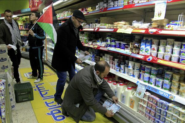 A Palestinian activist places a sign to boycott Israeli products at a supermarket in Bethlehem, West Bank. Most West Bank shops no longer carry the products of six major Israeli food companies, as a boycott triggered by rising Israeli-Palestinian tensions is taking hold, a boycott leader said Sunday, March 1, 2015. Activists in the Fatah movement of Palestinian President Mahmoud Abbas announced the boycott plans last month, after Israel halted transfer of vital tax revenues to Abbas' cash-strapped Palestinian Authority. A Palestinian activist places a sign to boycott Israeli products at a supermarket in Bethlehem, West Bank. Most West Bank shops no longer carry the products of six major Israeli food companies, as a boycott triggered by rising Israeli-Palestinian tensions is taking hold, a boycott leader said Sunday, March 1, 2015. Activists in the Fatah movement of Palestinian President Mahmoud Abbas announced the boycott plans last month, after Israel halted transfer of vital tax revenues to Abbas' cash-strapped Palestinian Authority. - Sputnik International