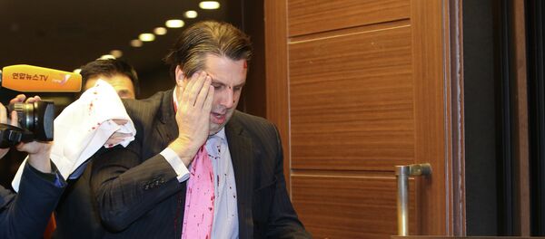 US ambassador to South Korea Mark Lippert (C) covers a wound to his face as he leaves the Sejong Cultural Institute in Seoul on March 5, 2015 - Sputnik International