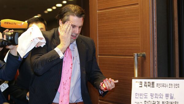 US ambassador to South Korea Mark Lippert (C) covers a wound to his face as he leaves the Sejong Cultural Institute in Seoul on March 5, 2015 - Sputnik International